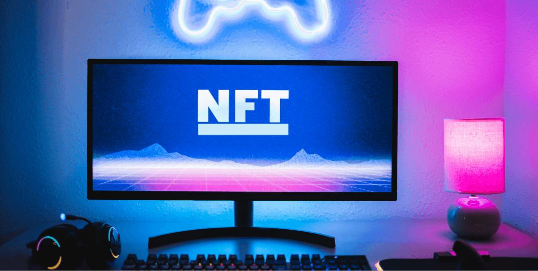 Big TV screen on a desk in a blue and pink light room displaying the capital letters: 'NFT'