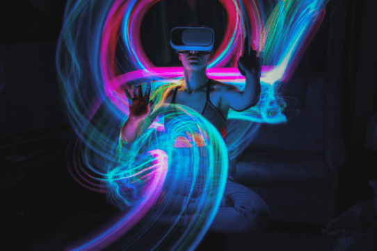 Abstract image of woman wearing a VR headset and moving hands in the air of the metaverse.